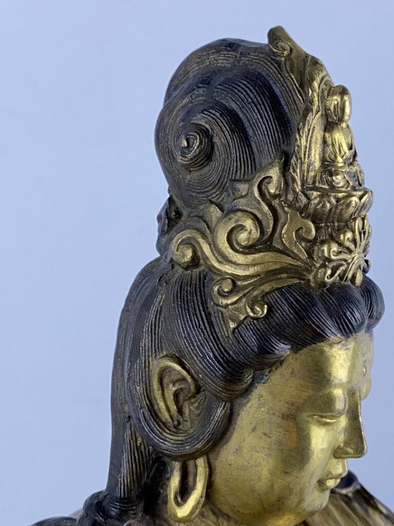 Guanyin en bronze doré - Chine - Représentée assise sur son rocher, la main dro…