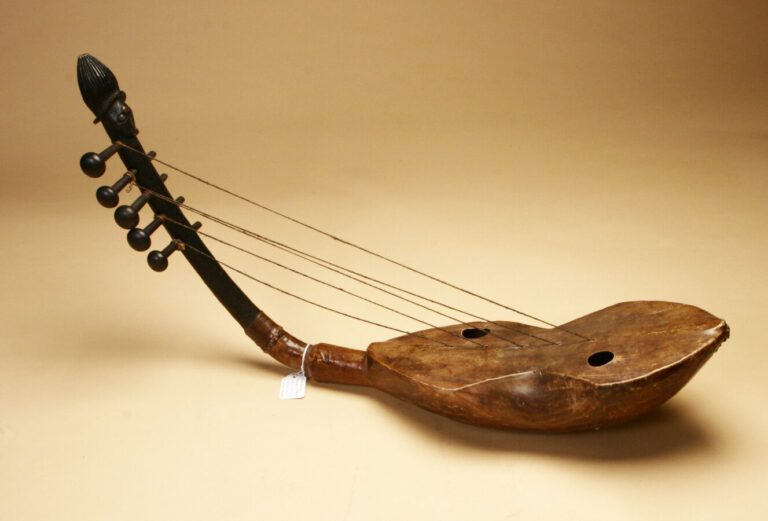 Harpe à 5 cordes, le manche décoré d'une tête, les yeux incrustés de clous de t…