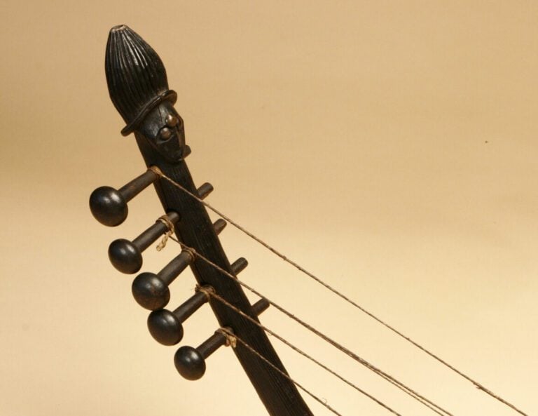 Harpe à 5 cordes, le manche décoré d'une tête, les yeux incrustés de clous de t…