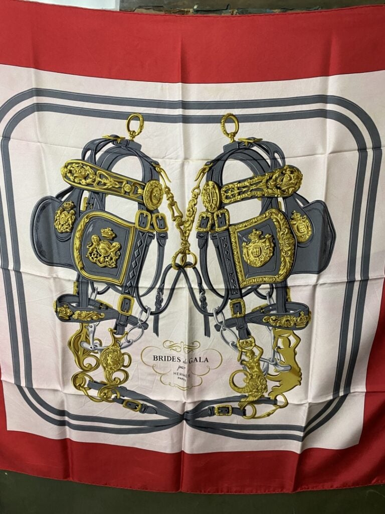 HERMÈS - Carré en soie «Brides de gala» dessiné par H.Grygkar, bordure rouge fo…