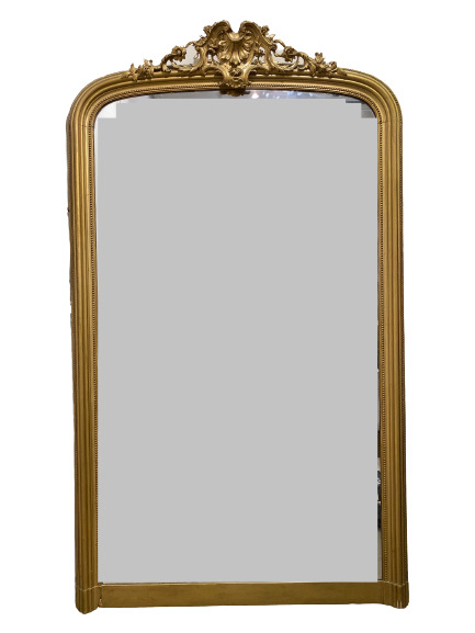 Important miroir en bois doré à décor de frises de perles et fronton sculpté de…