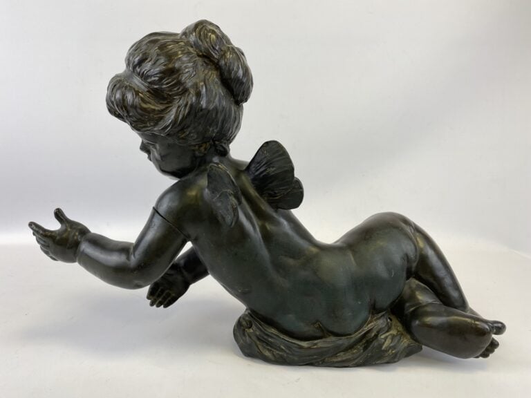 Important sujet en bronze à patine noire représentant un angelot allongé les br…