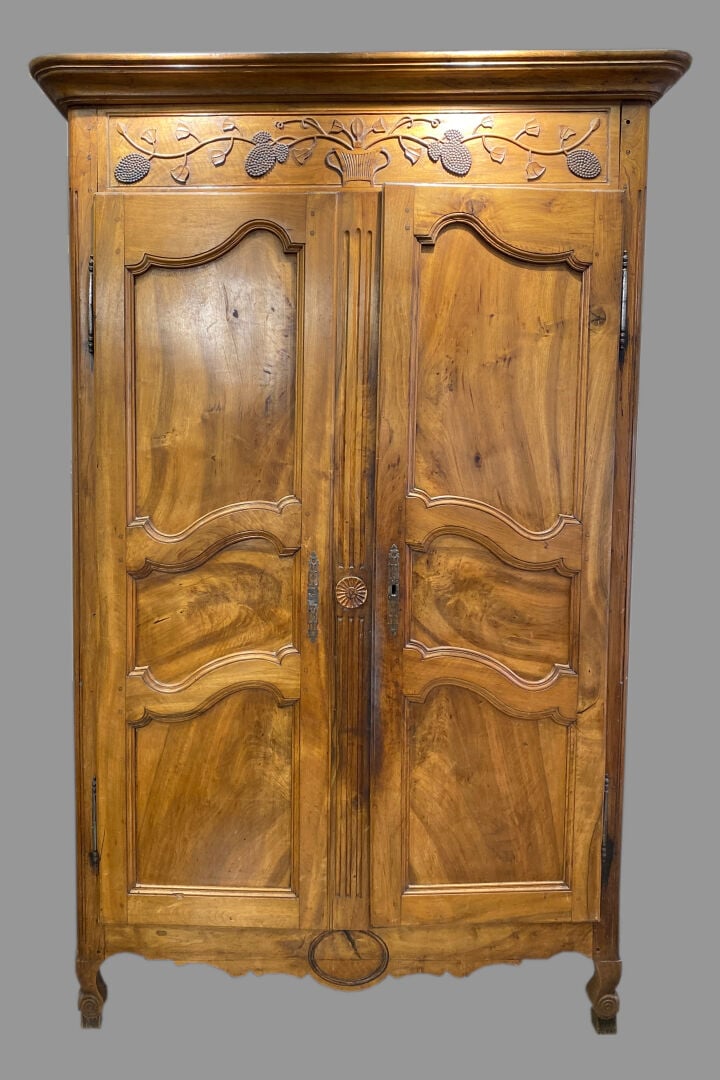 Importante armoire en noyer ouvrant par deux portes soulignées de moulures, la…