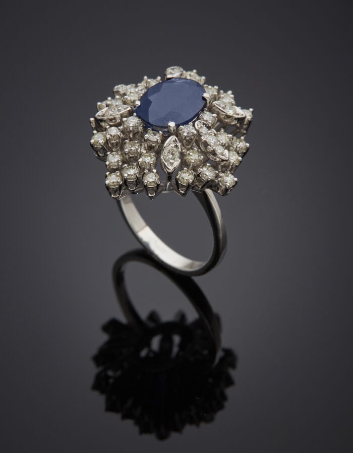 Importante BAGUE « cocktail » en or gris (750‰) serti d'un saphir ovale, entour…