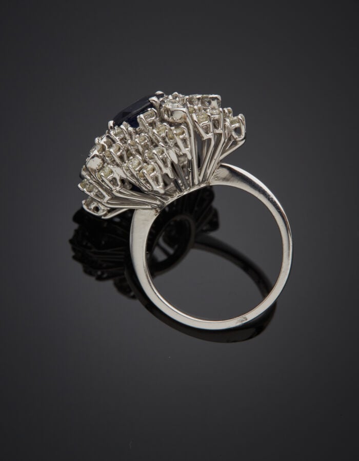 Importante BAGUE « cocktail » en or gris (750‰) serti d'un saphir ovale, entour…