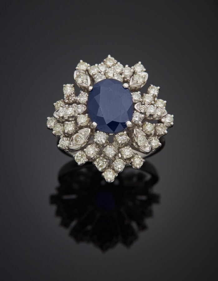 Importante BAGUE « cocktail » en or gris (750‰) serti d'un saphir ovale, entour…