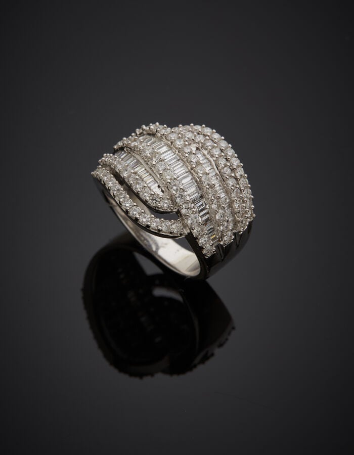 Importante BAGUE « volutes » en or gris (750‰) ajouré, serti de six alignements…