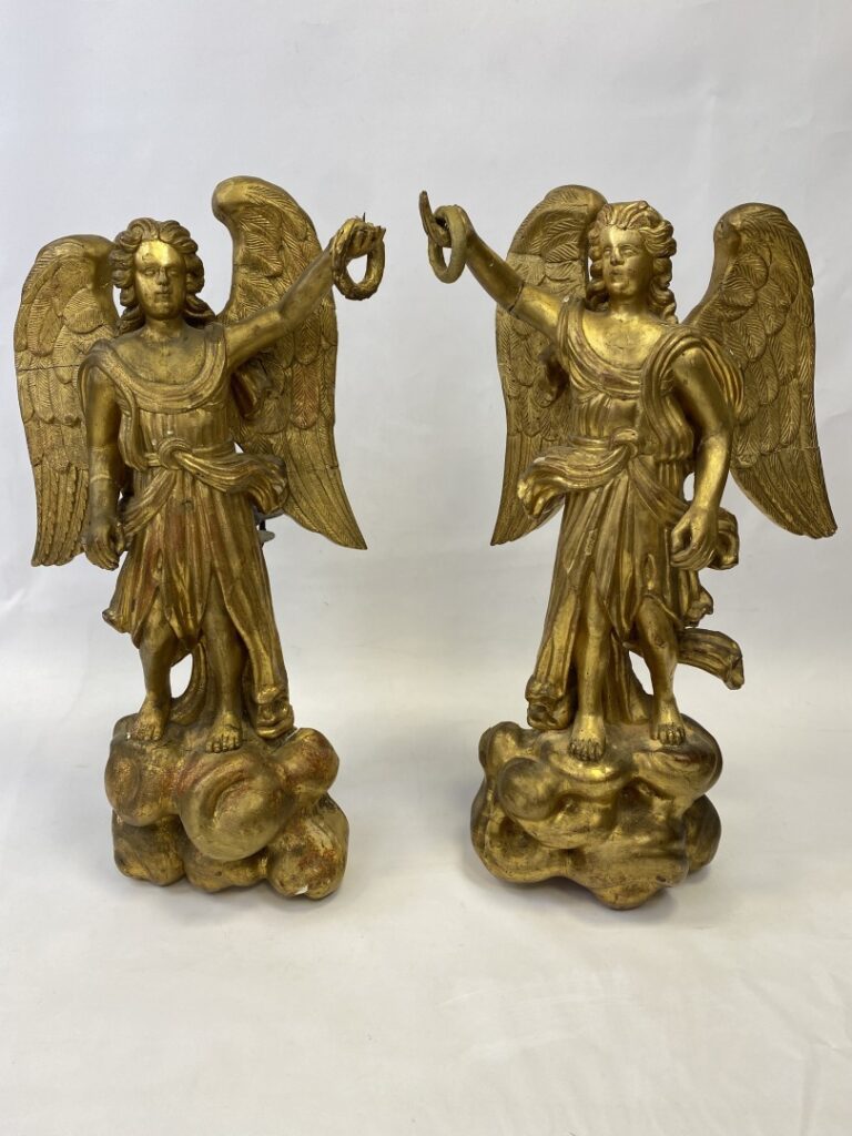 Importante paire d'anges en bois doré représentés debout ailes déployées sur un…