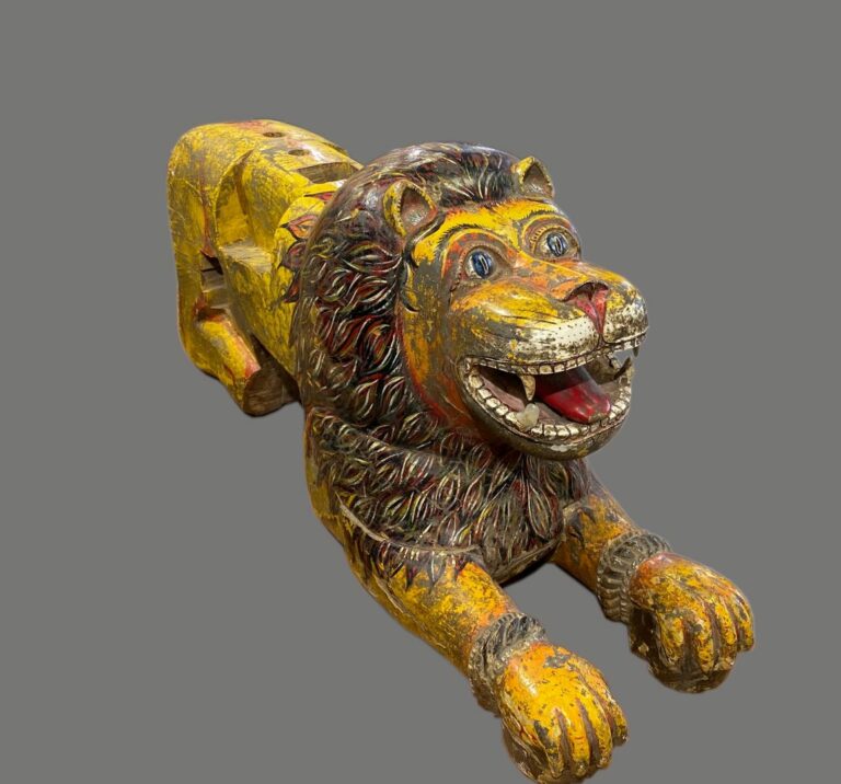 INDE - Important lion en bois sculpté et peint. Il est représenté allongé, la g…
