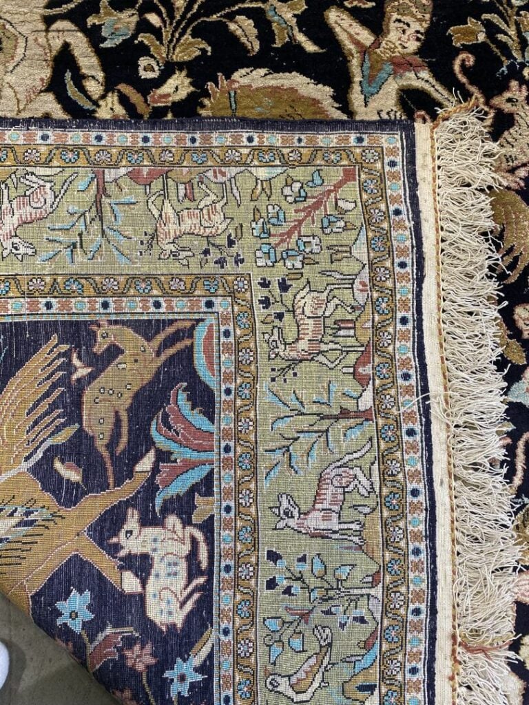 IRAN - Tapis Ghoum en soie à décor de cavaliers sur fond noir, bordure animée d…