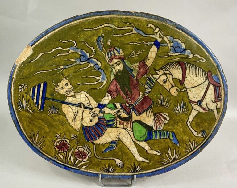 IRAN, XXe - Plaque ovale en céramique émaillée polychrome à décor de cavalier c…
