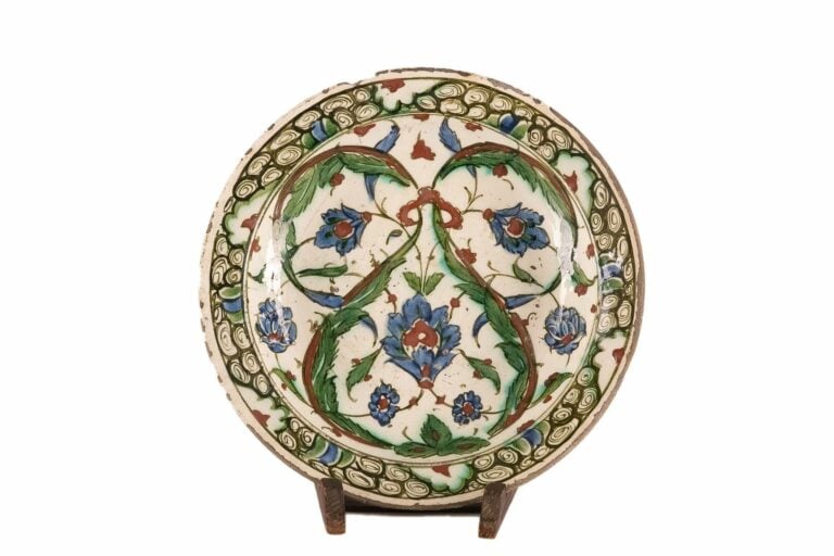 IZNIK - Plat rond en céramique siliceuse, à décor de deux palmes saz en enroule…