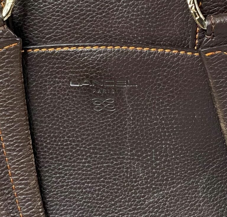 LANCEL - Sac Adjani en cuir grainé chocolat et surpiqûres oranges, à double poi…