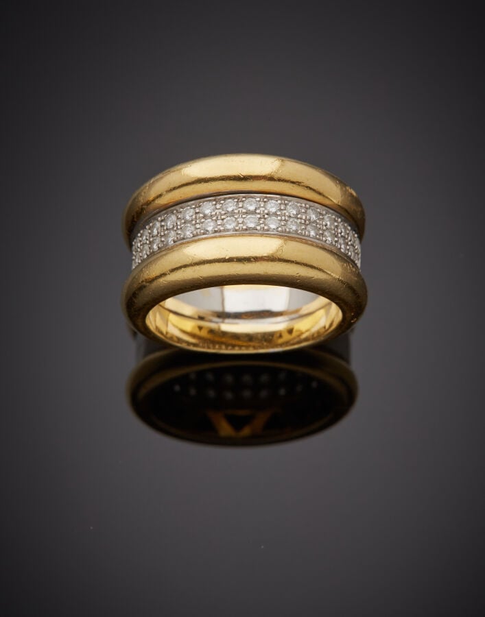 Large BAGUE en or jaune et or gris (750‰) composée de deux joncs séparés par un…