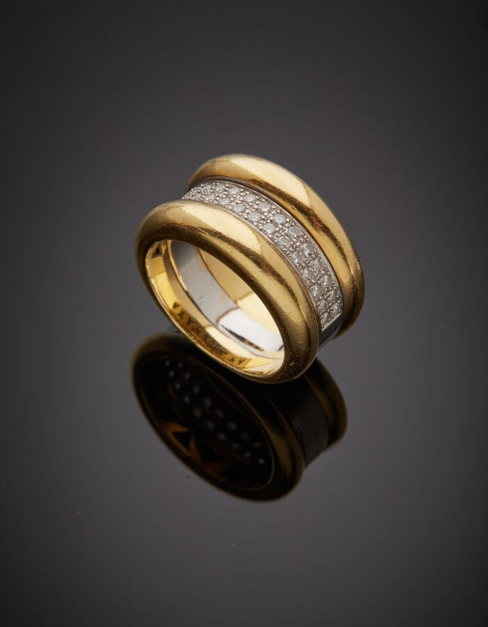 Large BAGUE en or jaune et or gris (750‰) composée de deux joncs séparés par un…