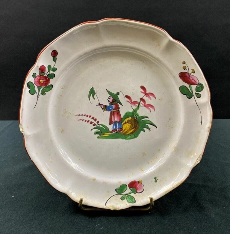 LES ISLETTES - Assiette à bord contourné, décor polychrome d'un Chinois tenant…