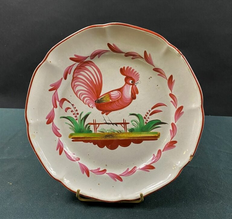 LES ISLETTES - Assiette à bord contourné, décor polychrome d'un coq posé sur un…