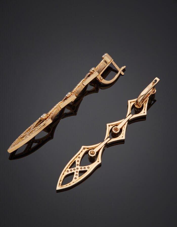 Longue paire de PENDANTS d'OREILLES articulées en or rose (750‰) ajouré, à moti…