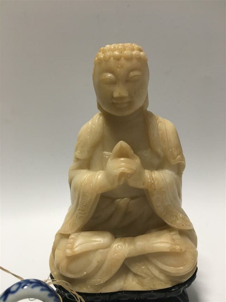 Lot comprenant: - - un bouddha en pierre dure sur son socle - (collé sur son so…