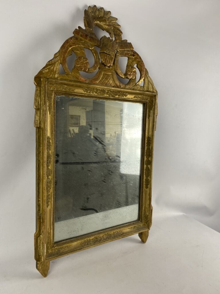 Miroir à fronton en bois et stuc doré à décor de frises de raies de coeur et pa…