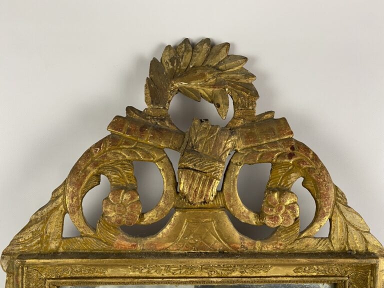 Miroir à fronton en bois et stuc doré à décor de frises de raies de coeur et pa…