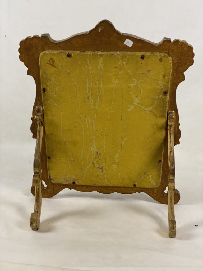 Miroir à poser en bois et stuc doré à décor d'enroulements et surmonté d'une co…