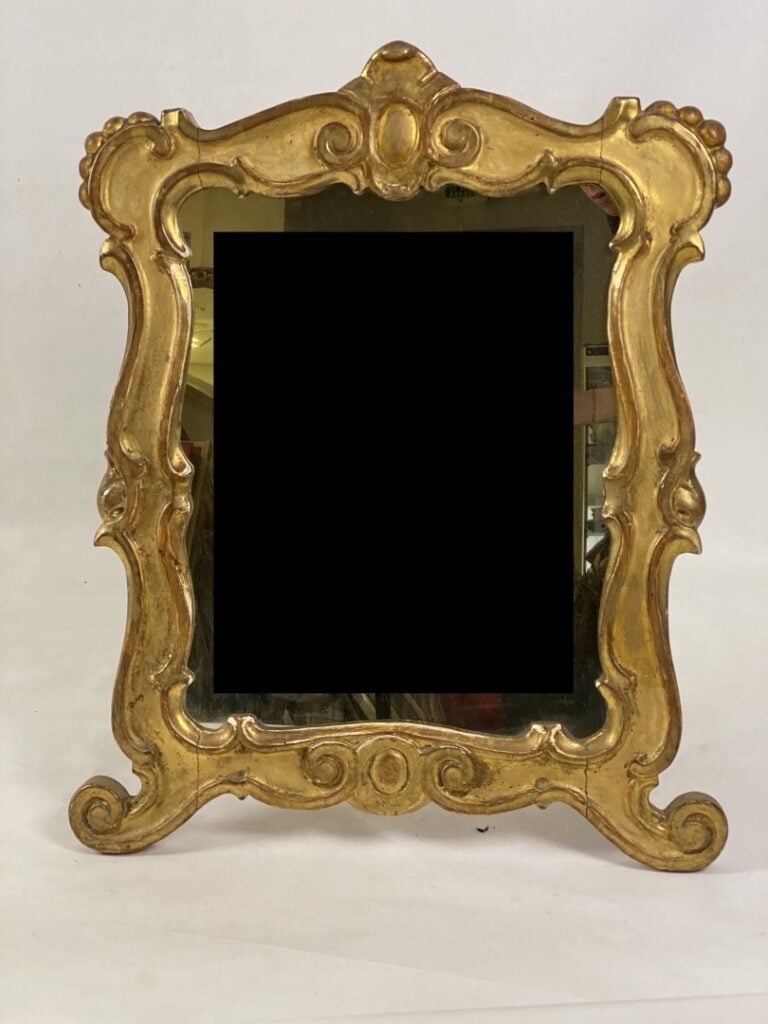 Miroir à poser en bois et stuc doré à décor d'enroulements et surmonté d'une co…