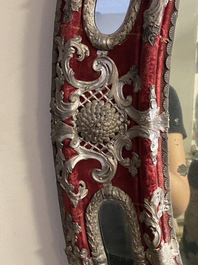 Miroir de forme ovale en bois gainé de velours rouge et orné en alternance de m…