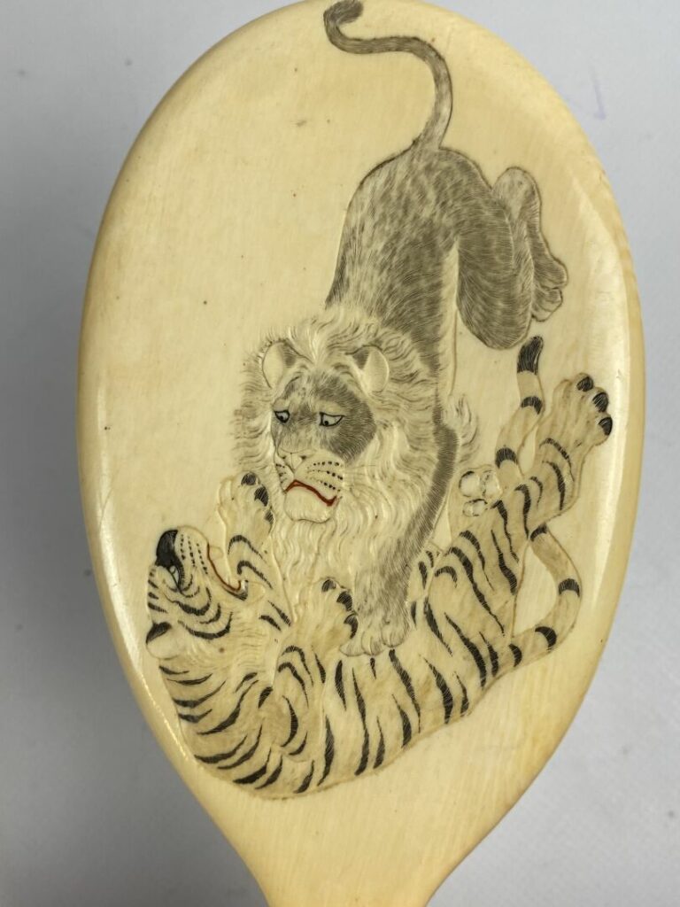 Miroir Face à main en ivoire à décor sculpté de lion attaquant un tigre - Japon…