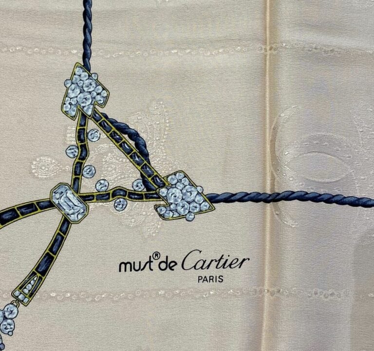 Must de CARTIER - Carré en soie à décor imprimé dans les tons gris de diadème,…