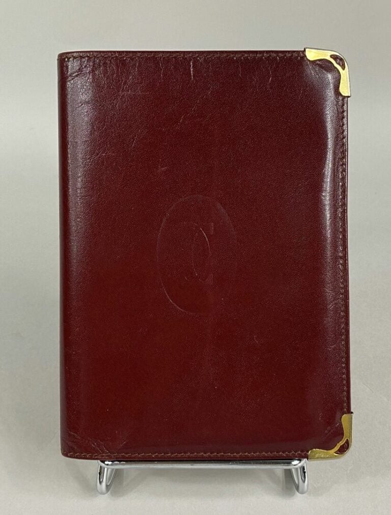 Must de CARTIER - Portefeuille à compartiments en cuir bordeaux - 15 x 10.5 cm…