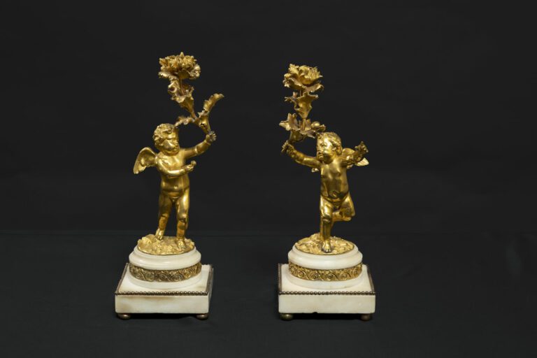 Paire de bougeoirs en bronze ciselé et doré figurant des putti ailés supportant…