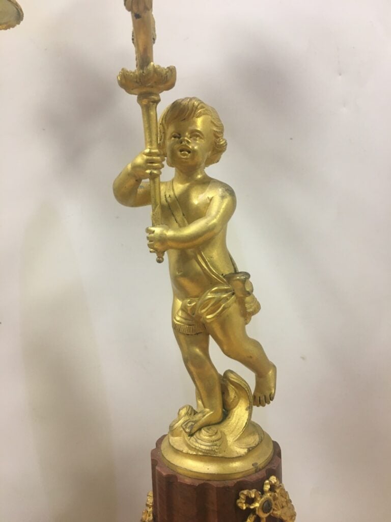 Paire de bougeoirs en bronze doré, représentant des putti supportant deux bras…