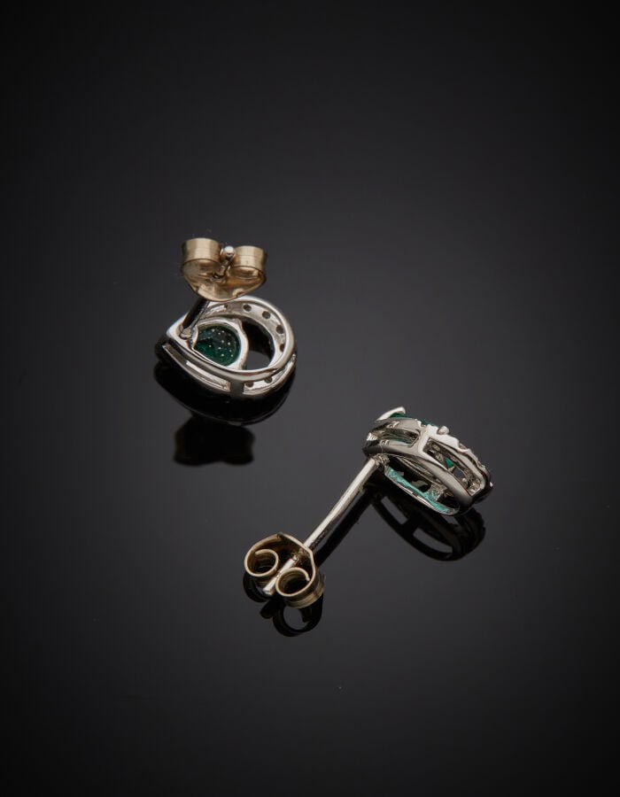 Paire de CLOUS d'OREILLES « gouttes » en or gris (750‰) ajouré, serti d'une éme…