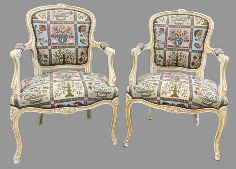Paire de fauteuils cabriolet en bois laqué crème mouluré et sculpté de fleurett…
