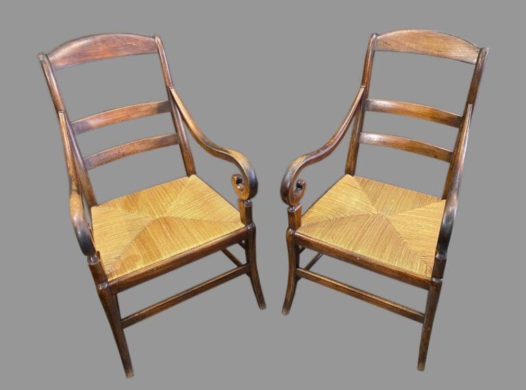 Paire de fauteuils paillés en noyer à dossier barrettes et accotoir à enrouleme…
