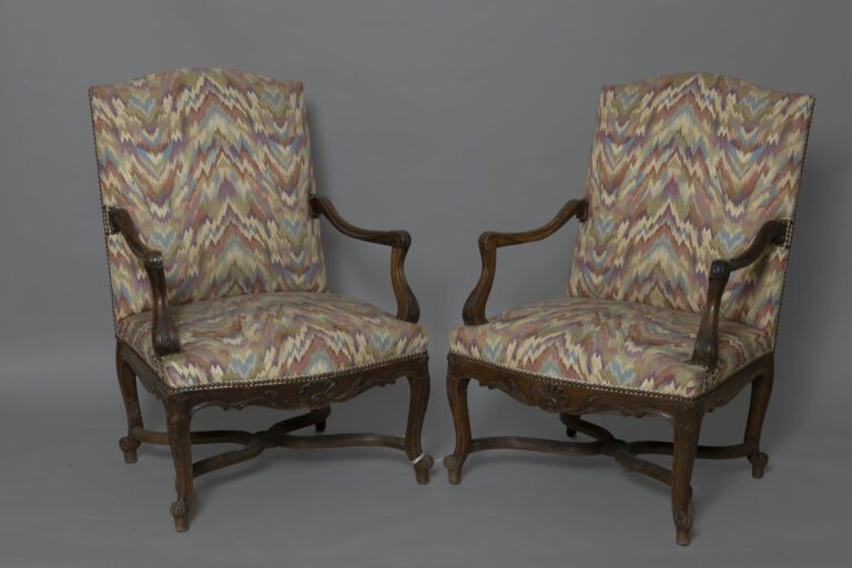 Paire de larges fauteuils à dossier plat en bois mouluré et sculpté de feuilles…