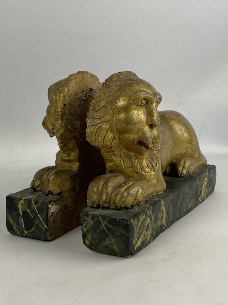 Paire de lions couchés pouvant former serre-livres en bois peint doré et sculpt…