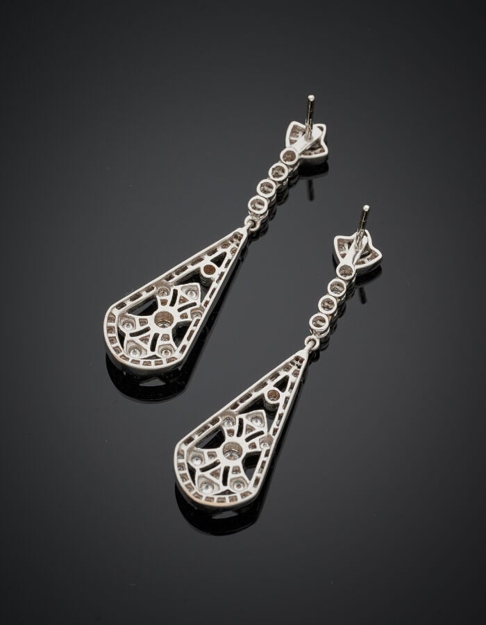 Paire de PENDANTS d'OREILLES "cravates" en or gris (750‰) ajouré, serti de diam…