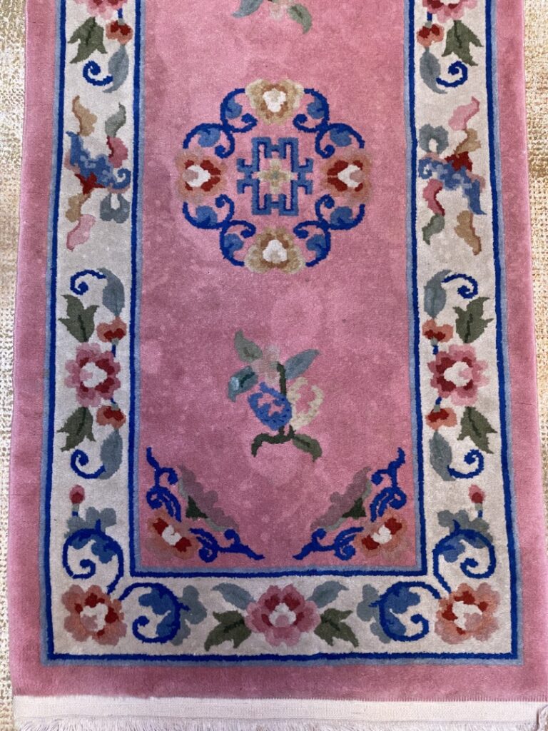 Paire de tapis chinois - Sur fond rose à décor de fleurs et motifs géométriques…
