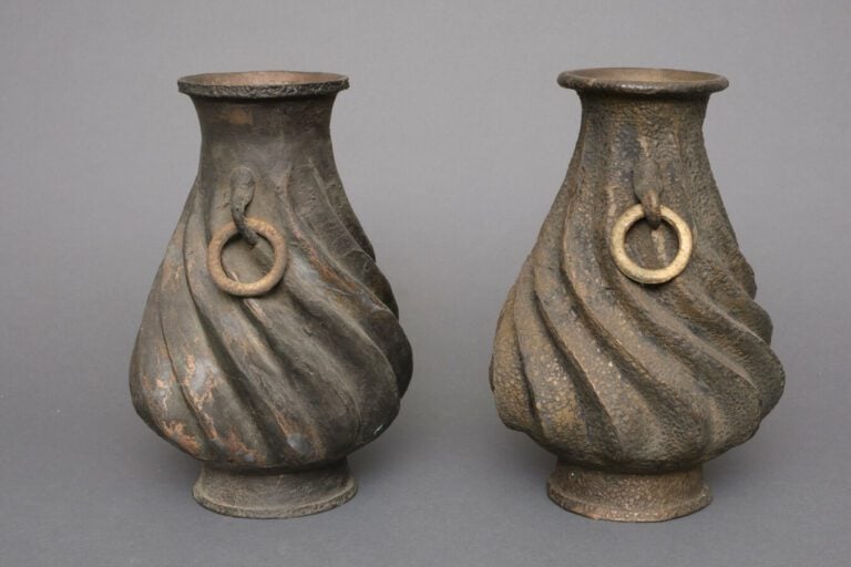 Paire de vases en métal à la surface rugueuse en forme de spirale. Les deux pos…