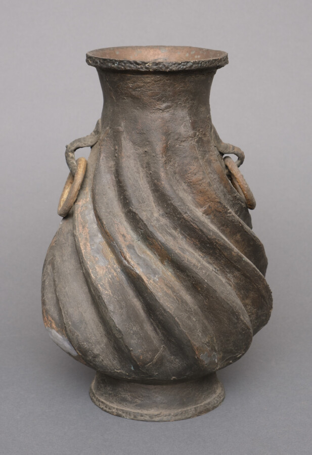 Paire de vases en métal à la surface rugueuse en forme de spirale. Les deux pos…
