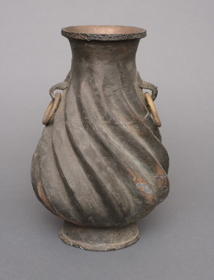Paire de vases en métal à la surface rugueuse en forme de spirale. Les deux pos…