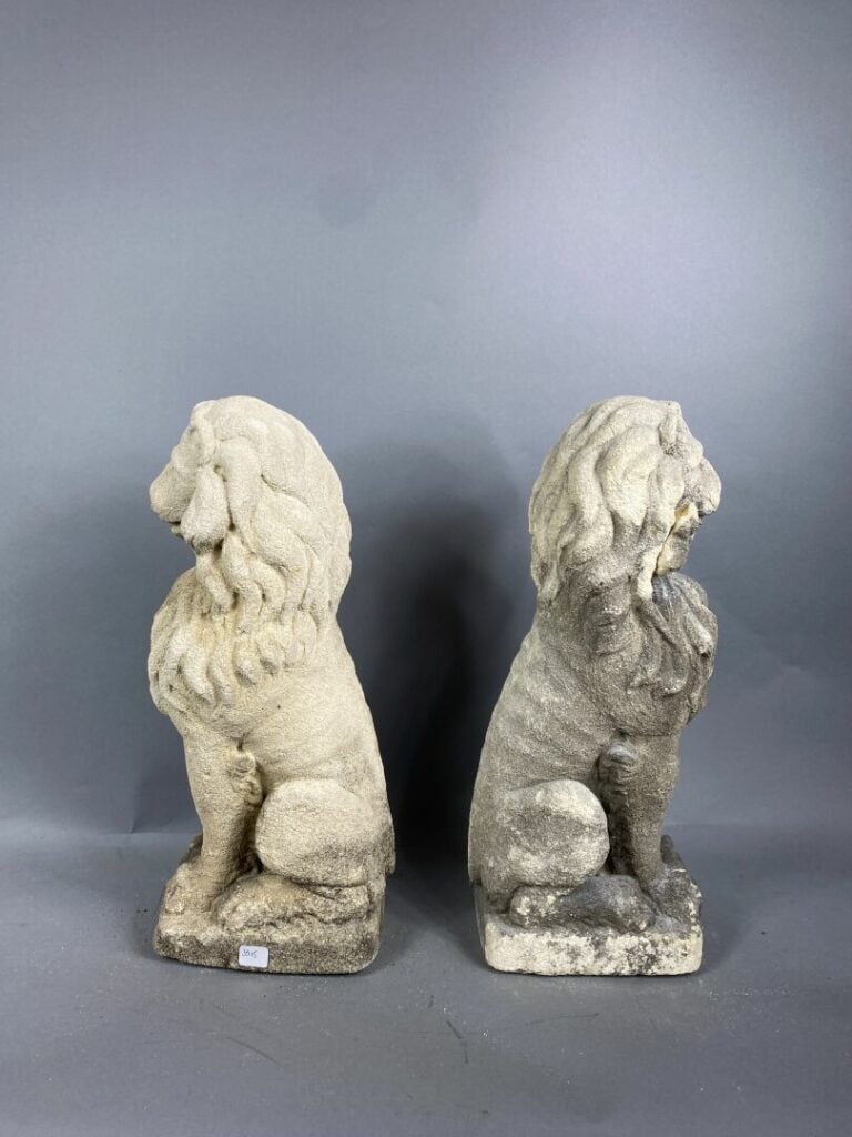 Paire d'ornements d'extérieur en pierre reconstituée figurant des lions assis -…