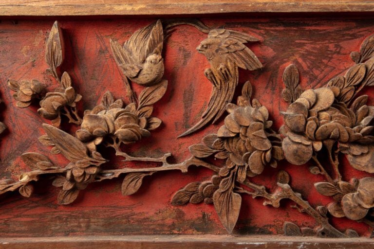 PANNEAU DE BOIS EN LAQUE ROUGE SCULPTE EN RELIEF - Chine - Au décor de vases fl…