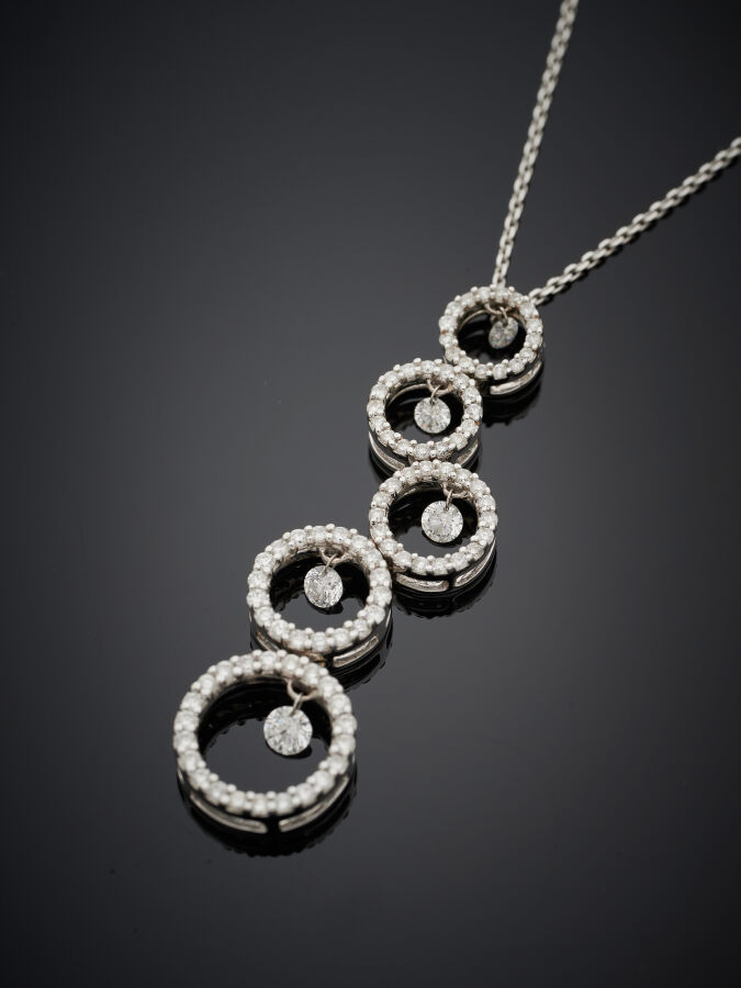PENDENTIF "cinq anneaux" et sa chaînette en or gris (750‰) serti de diamants ta…