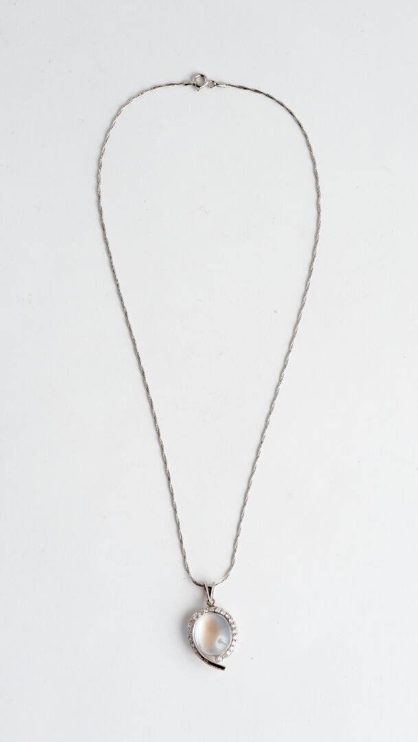 Pendentif goutte en or gris (750) orné d'un cabochon de pierre de lune bordé d'…