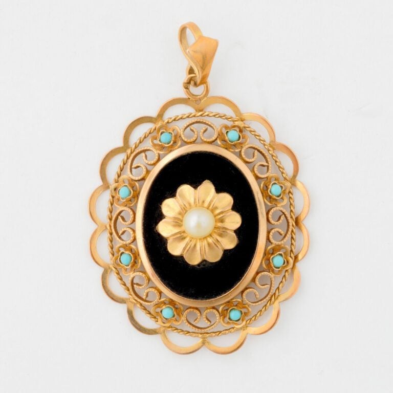 Pendentif médaillon en or jaune (750) et plaque d'onyx centré d'un motif de fle…