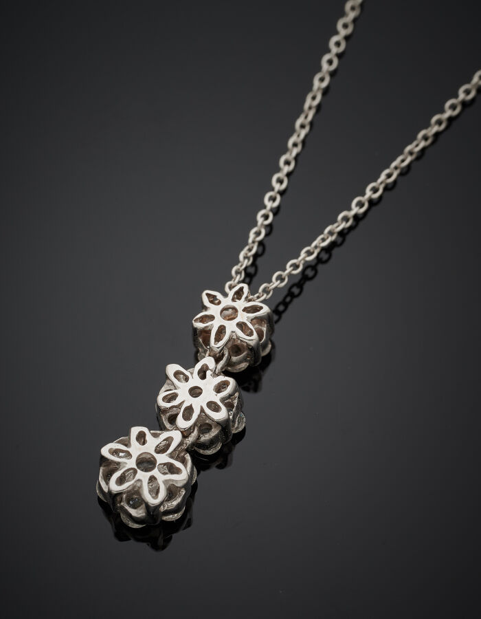 PENDENTIF "trois fleurettes" et sa chaînette en or gris (750‰) serti de diamant…