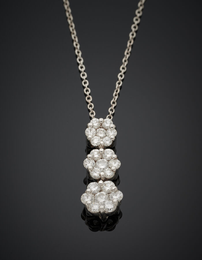 PENDENTIF "trois fleurettes" et sa chaînette en or gris (750‰) serti de diamant…
